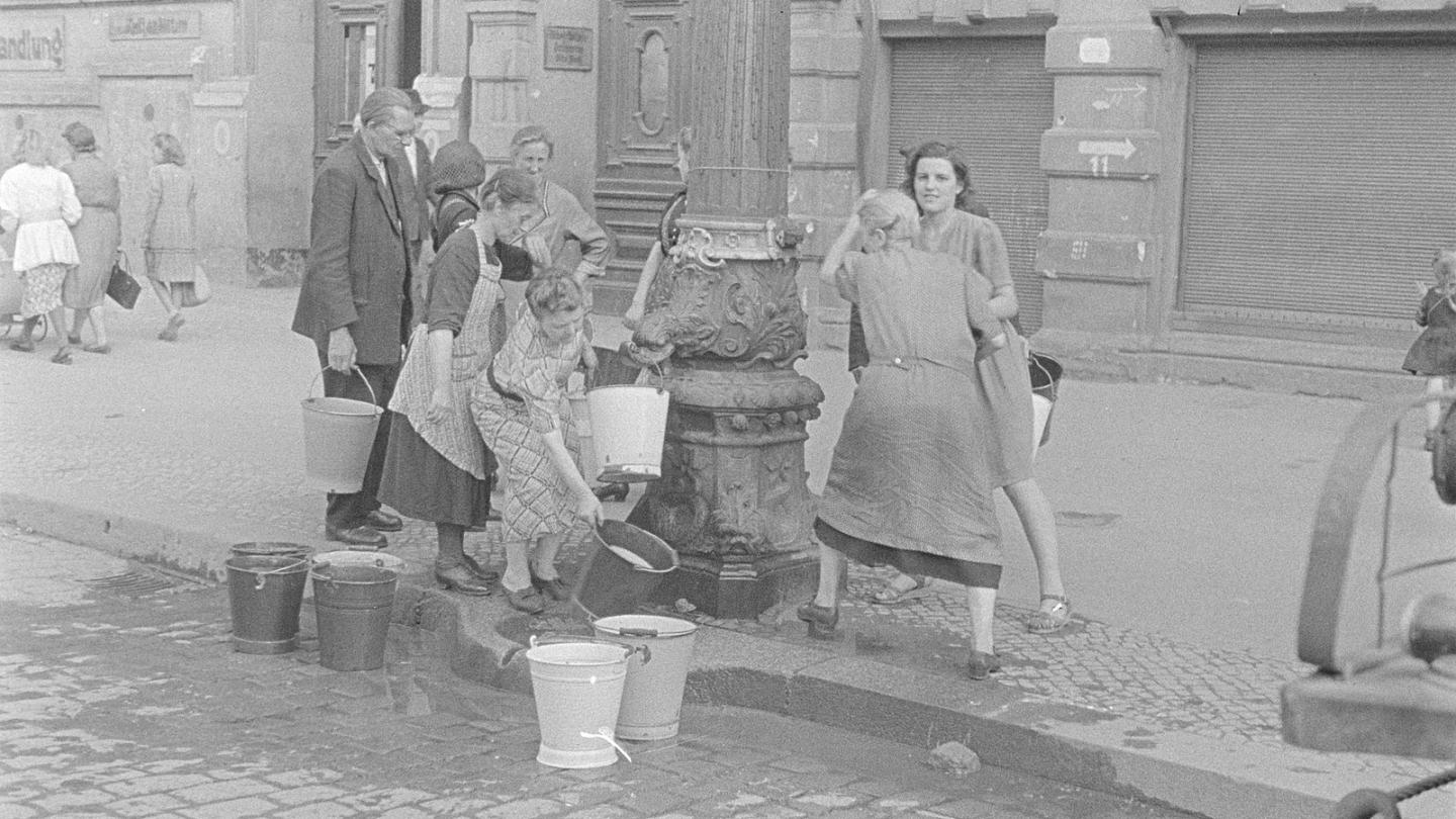 Frauen holen Wasser am Brunnen auf der Straße, Berlin 1945. Foto von Abraham Pisarek CC BY-SA 3.0 de