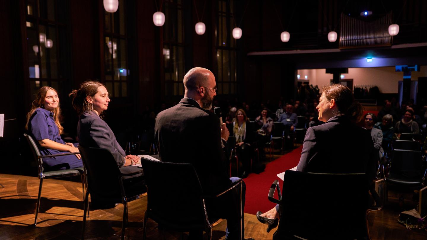Panel der drei Preisträger*innen von der Bühne aus fotografiert