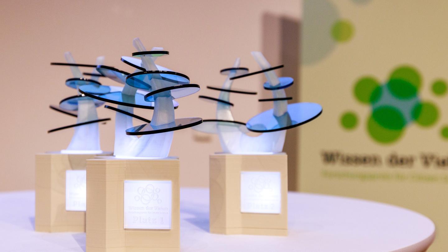 drei Troph&auml;en mit Beleuchtung auf einem Tisch